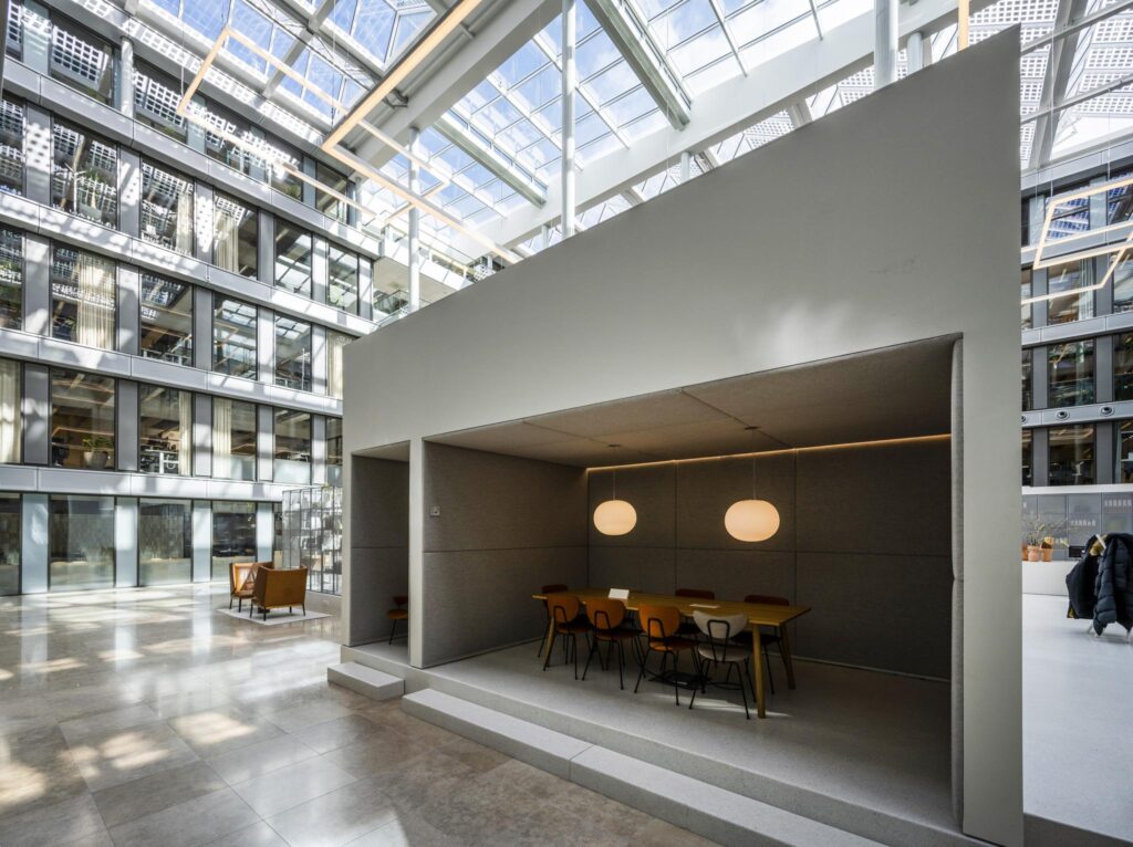 Modern indoor meeting space with pendant lighting inside a glass-roofed office building on Mr. Treublaan.